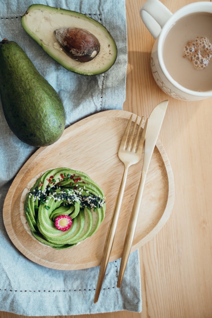 sliced avocado fruit on brown wooden chopping board