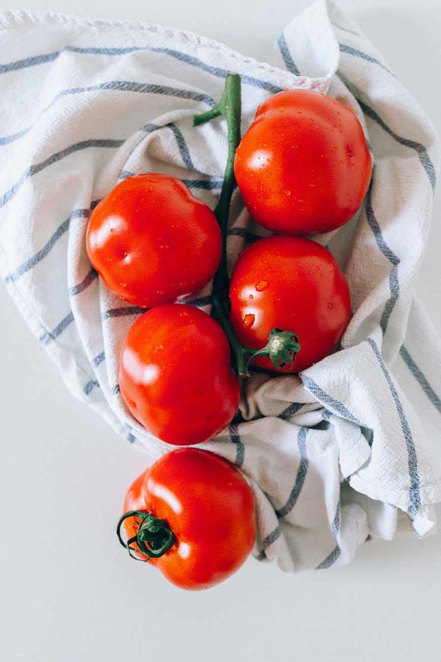 red tomatoes on white textile